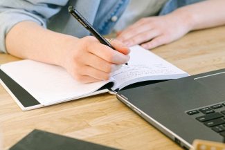 Frau schreibt Artikel an Schreibtisch